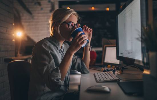 woman drinking coffee at home using canon software